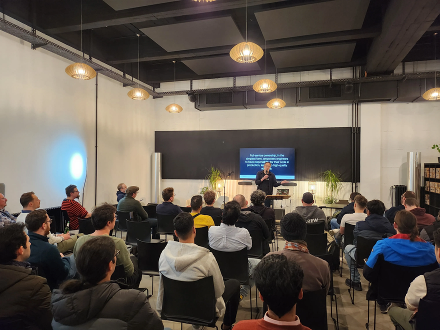 Speaker Constant Fischer discusses service ownership in front of an audience of dudes in hoodies.
